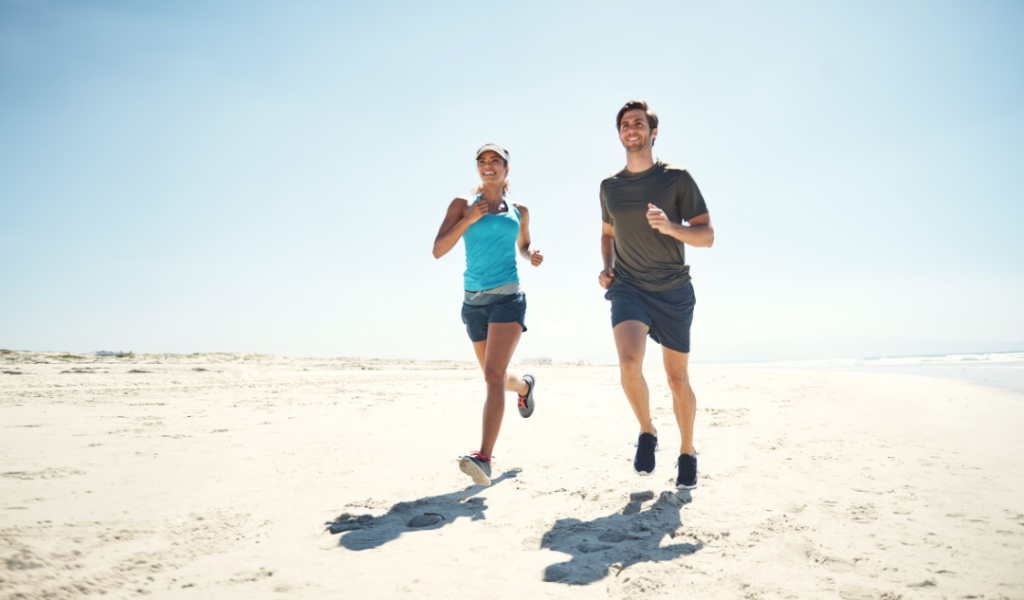 young athletic couple running in the beach