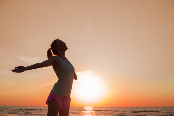 Kofermentas Q10: nauda, funkcijos ir vartojimo gairės Woman happily holding hands back in sunset