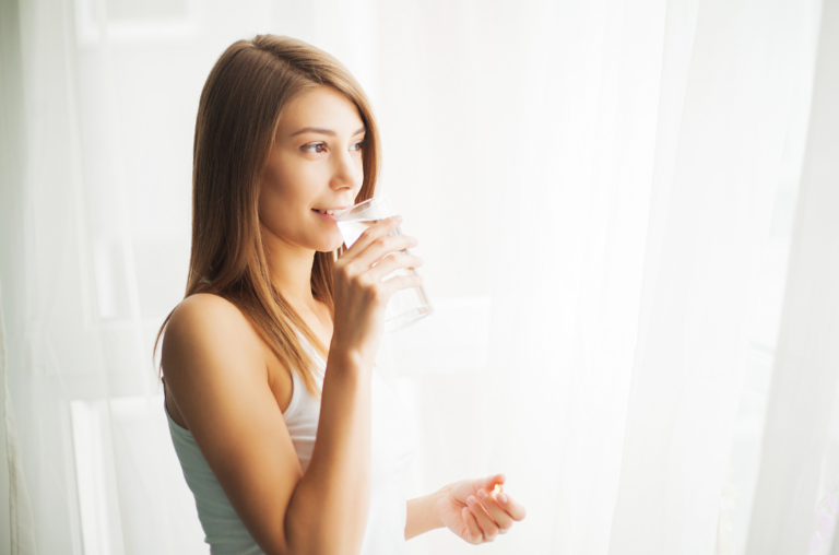 Woman taking supplement in the morning